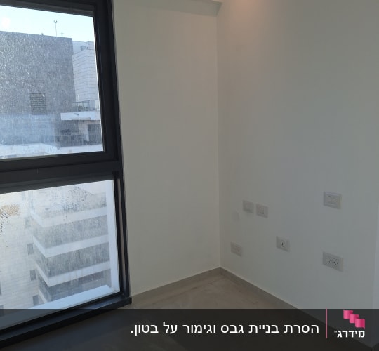 חדר עם חלון גדול ושקעים בקיר